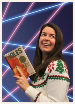 Librarian holding a book in front of a laser photo backdrop