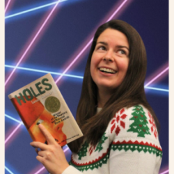 Librarian holding a book in front of a laser photo backdrop