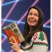 Librarian holding a book in front of a laser photo backdrop